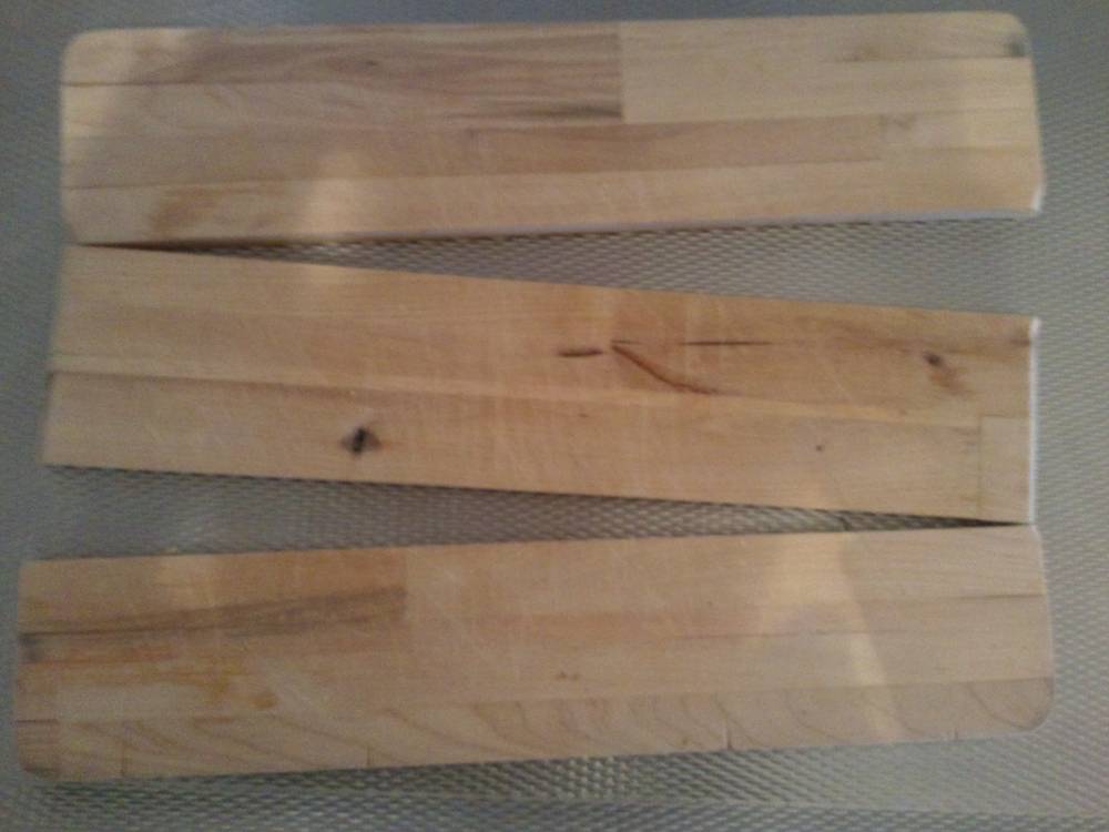 Three narrow strips of light wood, likely a cutting board that came apart after a trip through the dishwasher.