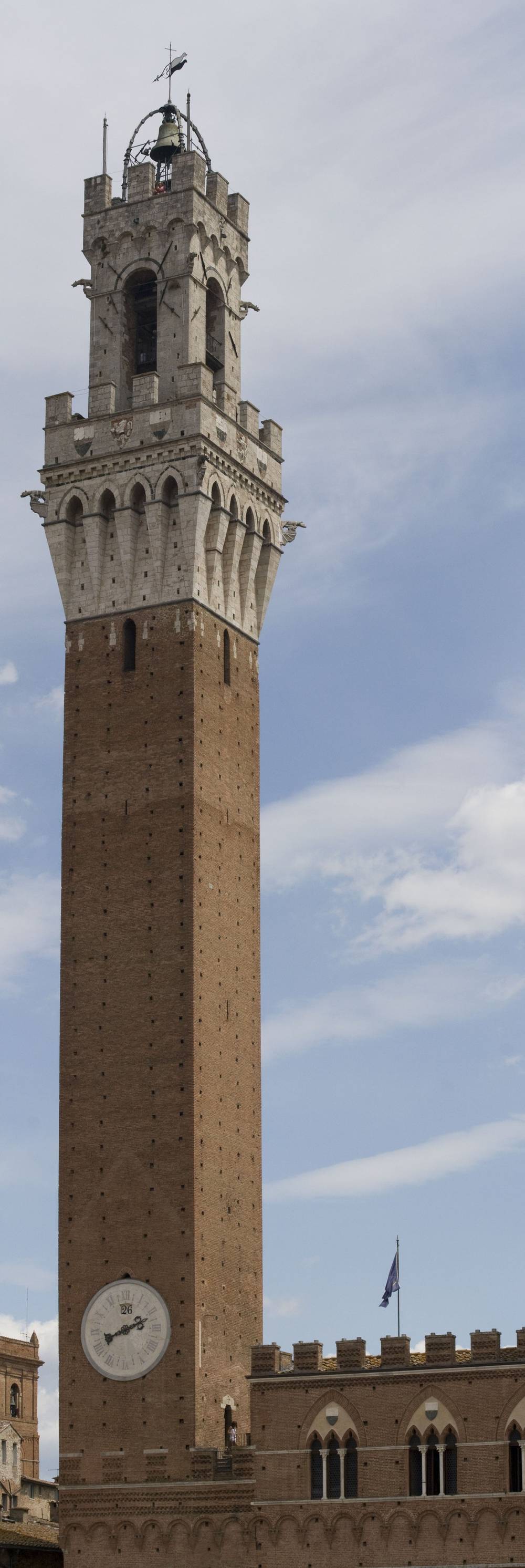 Siena's skyline and towers are seen in a wide panorama, sunlit against a clear sky.