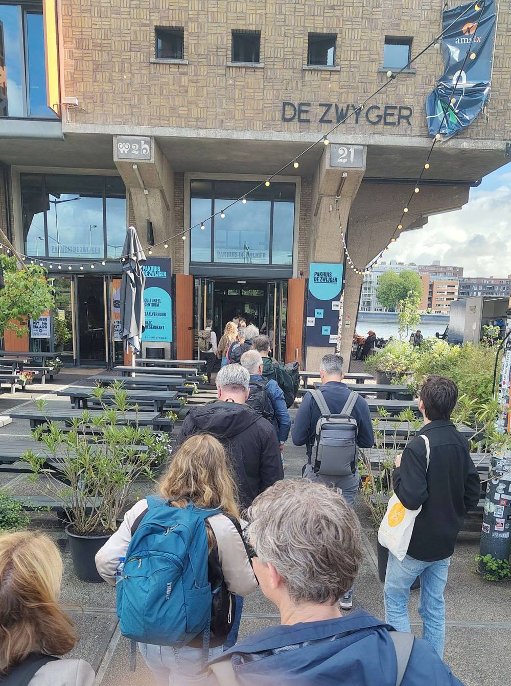 People queue outside a venue called "De Zwyger" for an event.