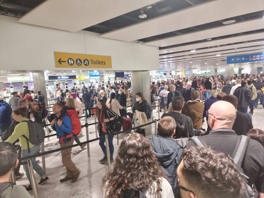 A crowded arrivals hall with a sign reading 'Welcome to Heathrow'.