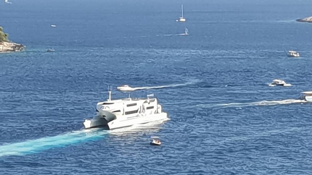 A ferry crossing the sea near the Croatian coast, with boats nearby.