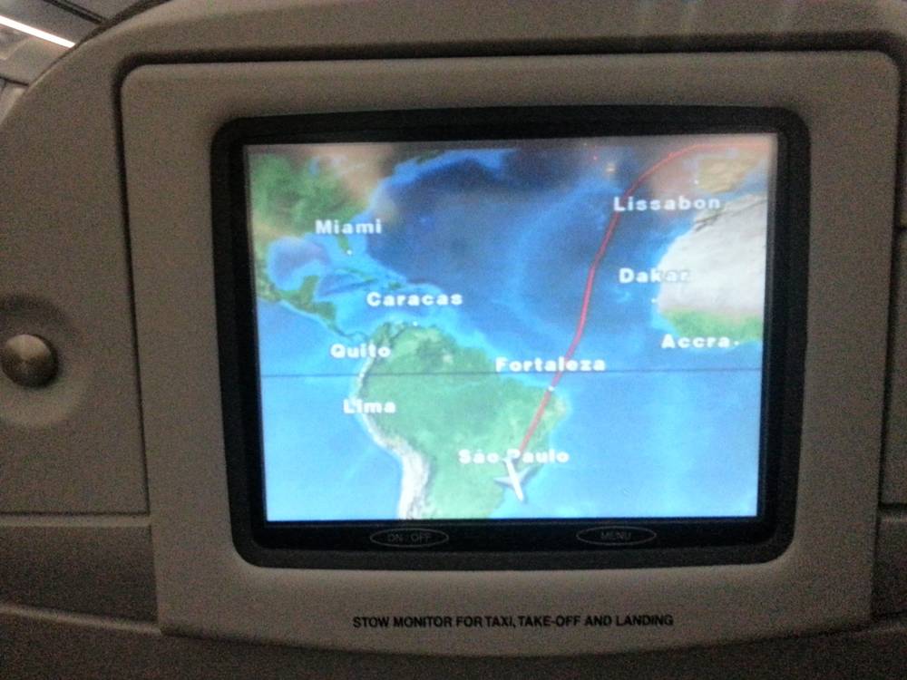 An airplane seatback screen showing a flight map with the route crossing the Atlantic toward Sao Paulo.