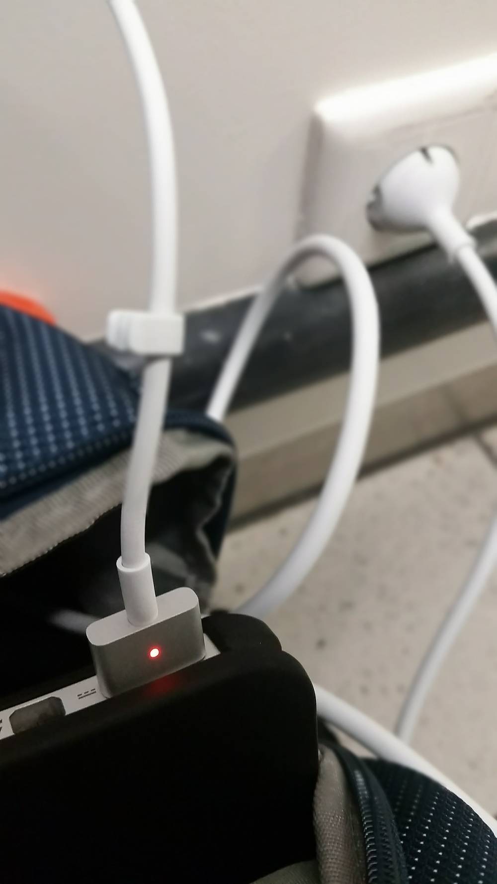 Several device chargers are tangled in a power outlet.