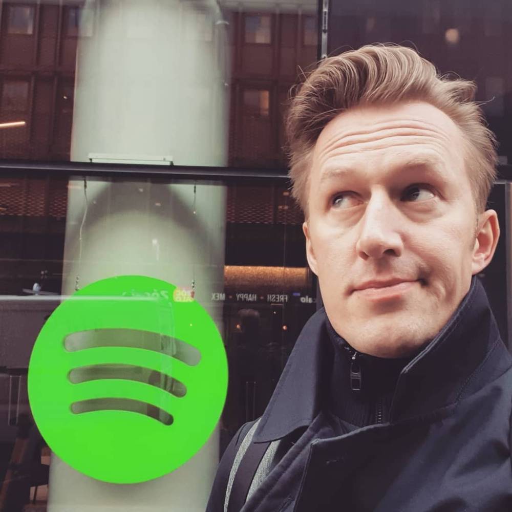 A man's reflection selfie with a Spotify logo overlay.