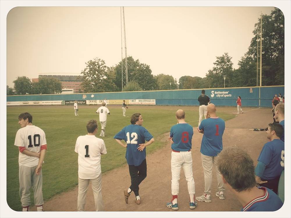 Baseball players and coaches gather on the field before a match.