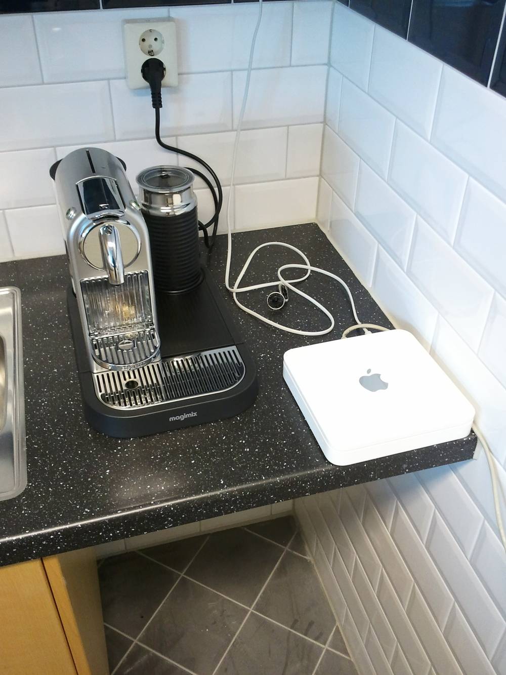 A Nespresso machine and Apple AirPort router sit on a kitchen counter in the new office.