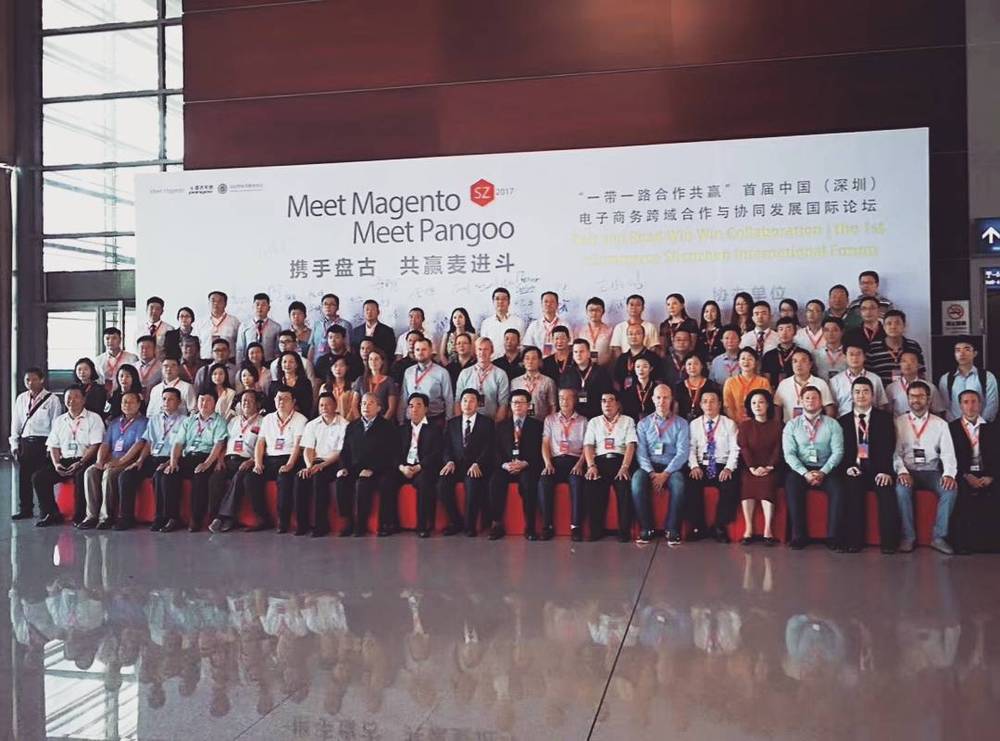 A large formal group photo of conference attendees posing together in front of an event backdrop.