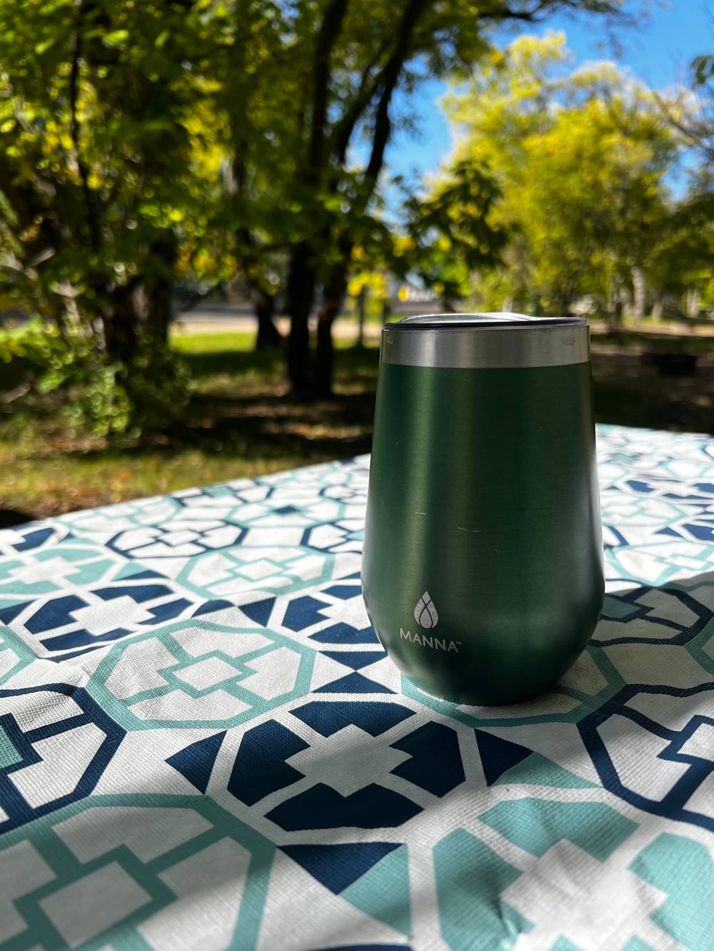A coffe mug on a table with fall foliage in the background