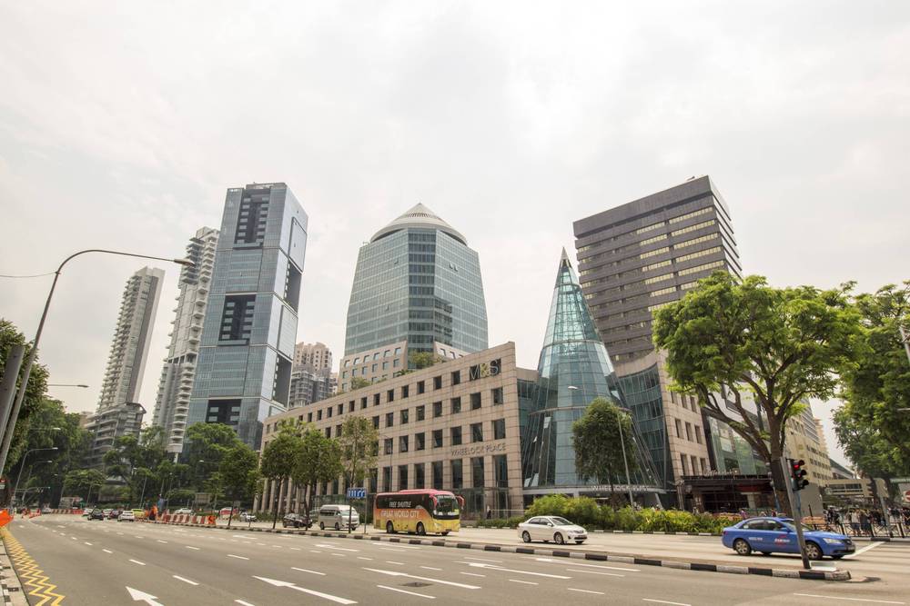 Modern towers, including a distinctive tapered skyscraper, rise along the street.
