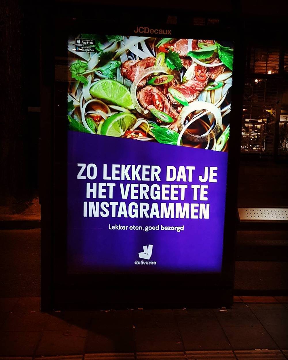 A digital street advertisement showing food, with Dutch text reading "Zo lekker dat je het vergeet te instagrammen" (so tasty you forget to Instagram it).