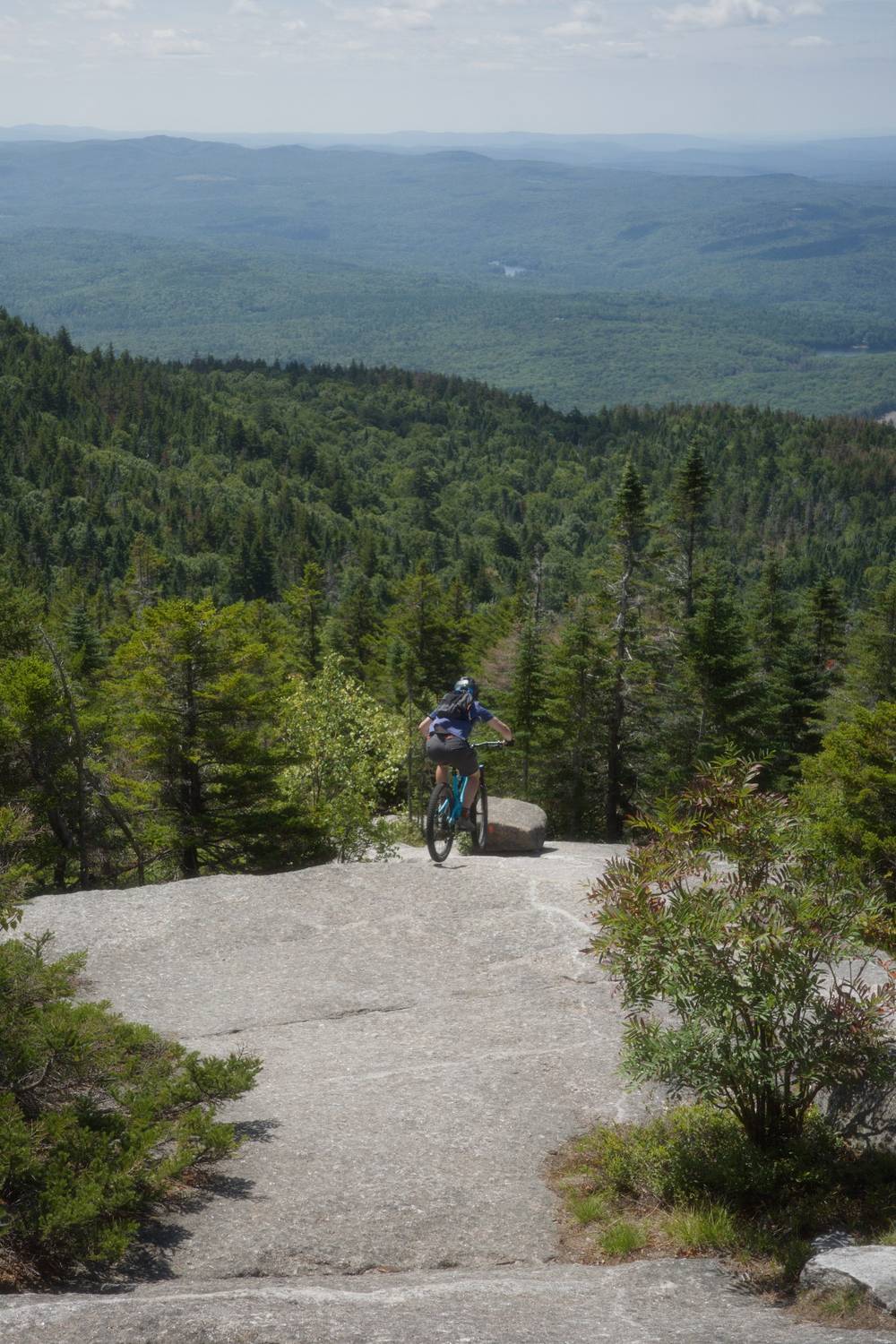 Rock face, cyclist, forested hills