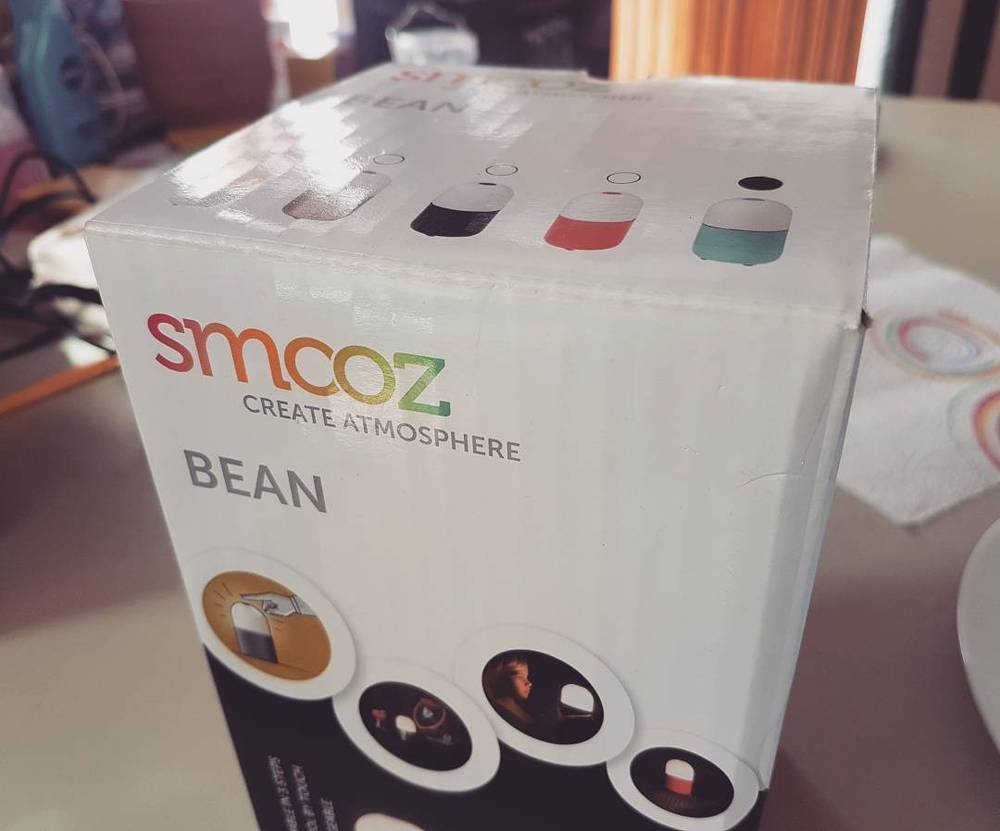 A boxed product called "Smcoz Bean," described as creating atmosphere, on a table.