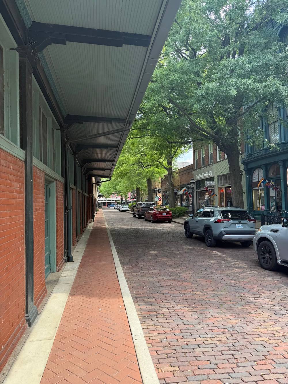 A cozy cobble stone street with tall green trees
