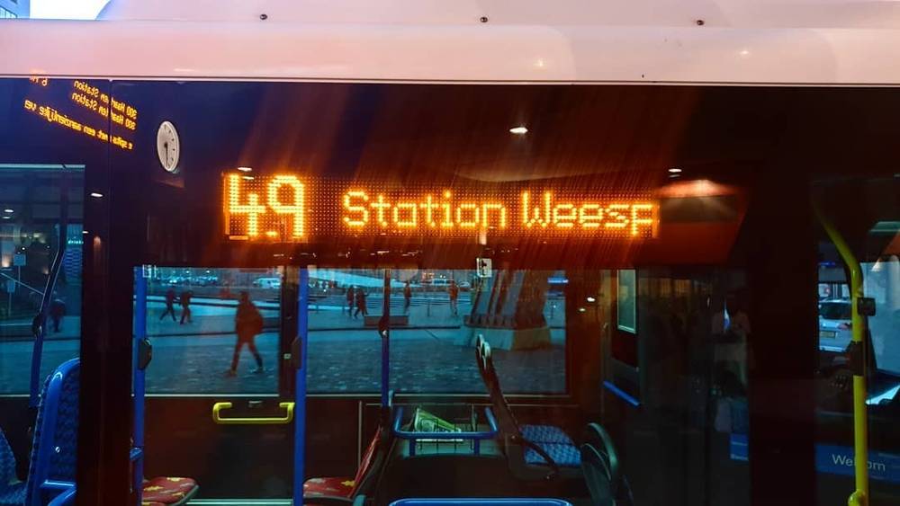A digital display inside a train reads "4.9 Station Weesp".