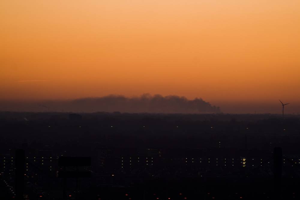 Distant factory fire at sunset