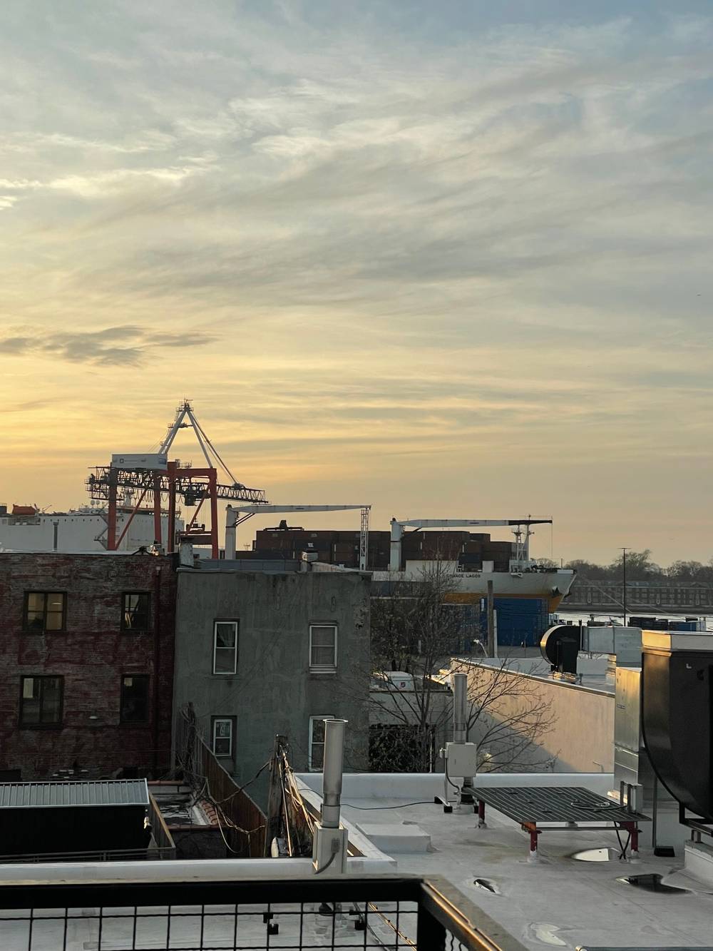 front part of cargo ship and a crane at sunset
