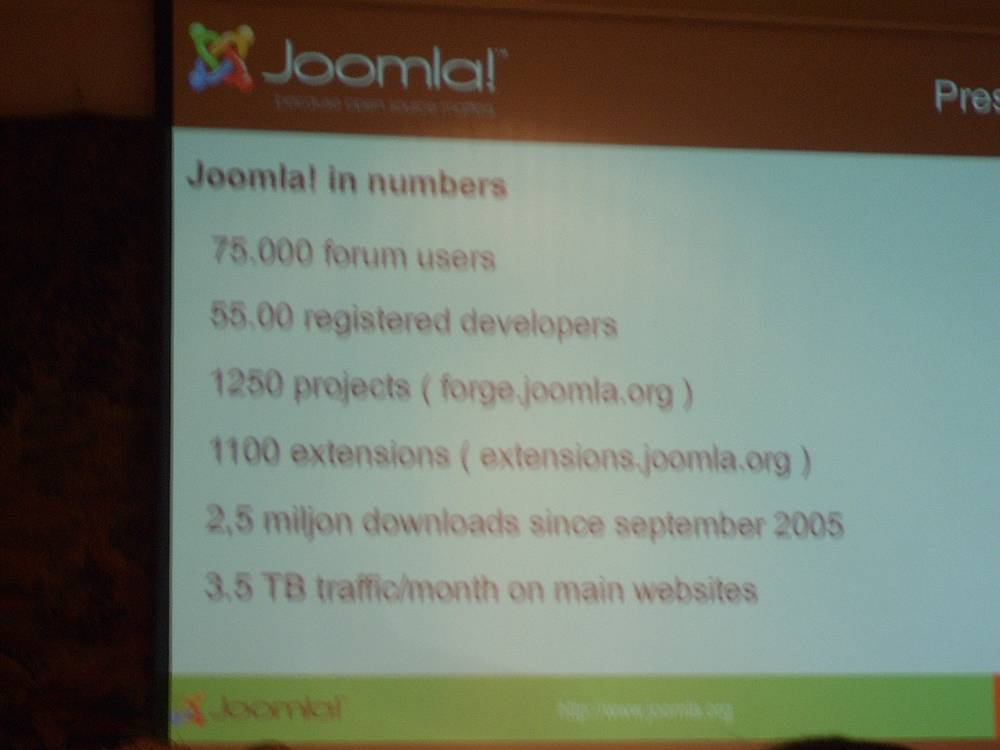 A projected slide lists "Joomla! in numbers" including forum users, downloads and traffic stats.