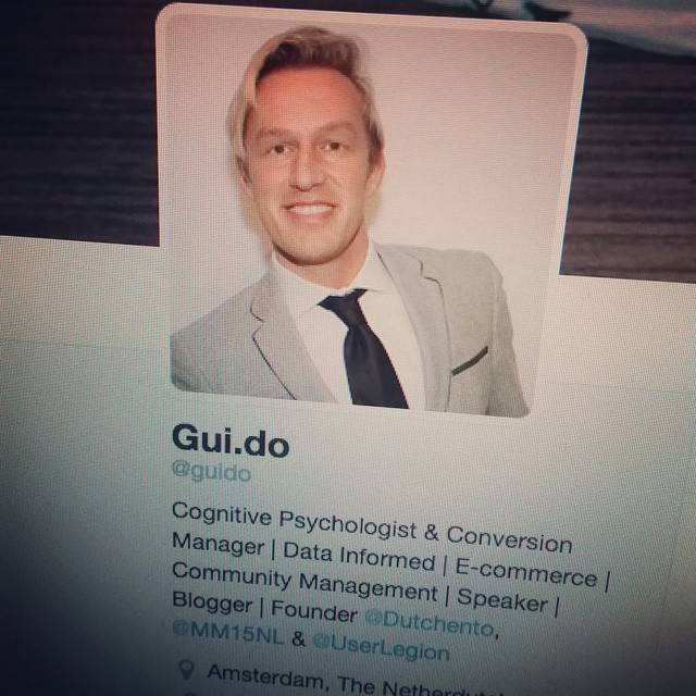 A screenshot of a Twitter profile named 'Gui.do' with the bio 'Cognitive Psychologist & Conversion Manager | Data Informed | E-commerce | Community Management | Speaker | Blogger | Founder', showing a man in a suit.