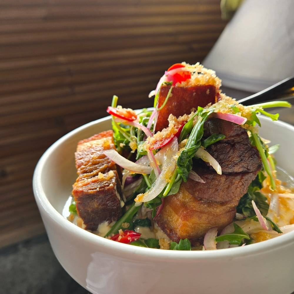 Pork belly on leafy veggies