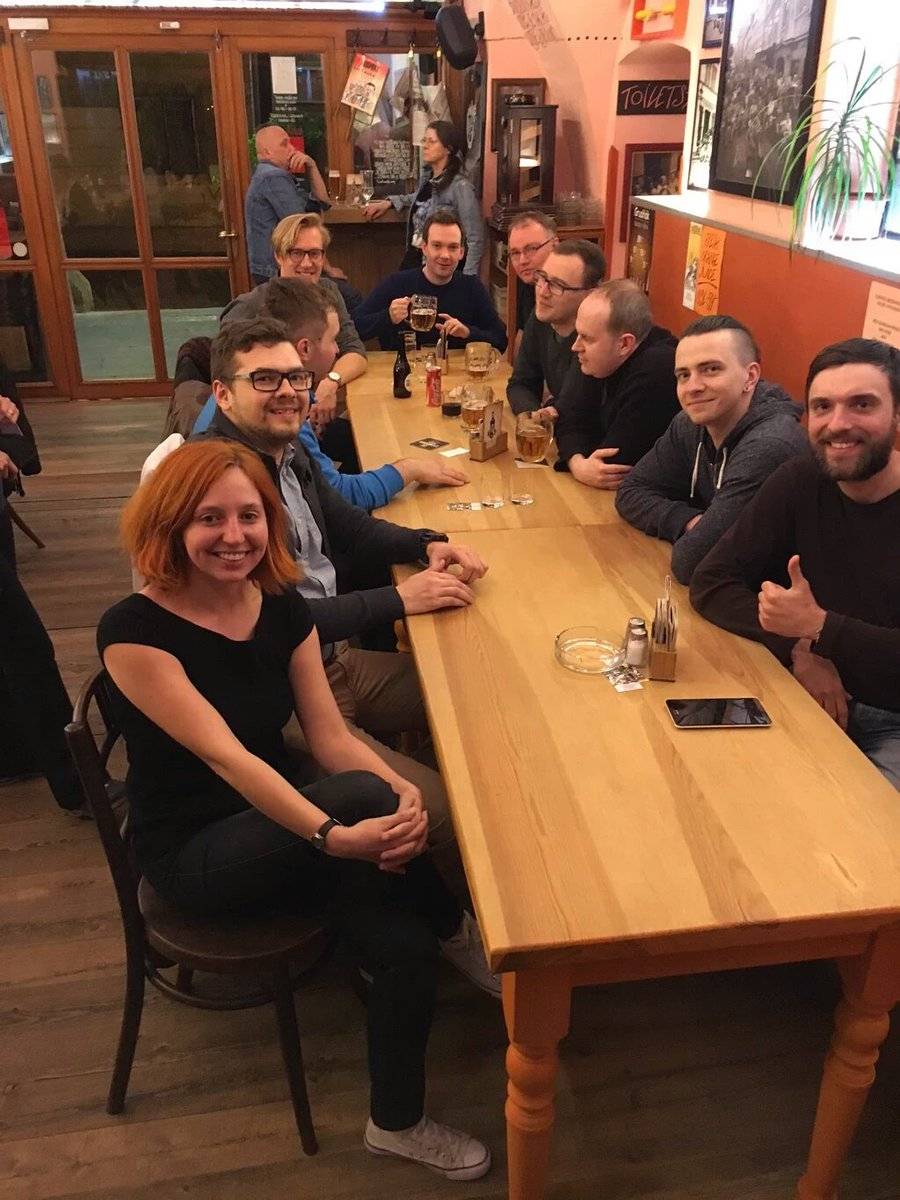 A group of people sit together at a long table in a restaurant.