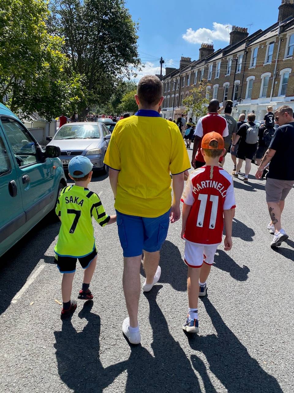My sons and I walking along a road in Arsenal shirts