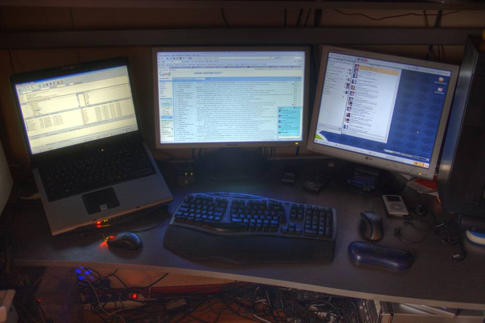 The same desk setup with laptop and dual monitors, a near-identical frame.