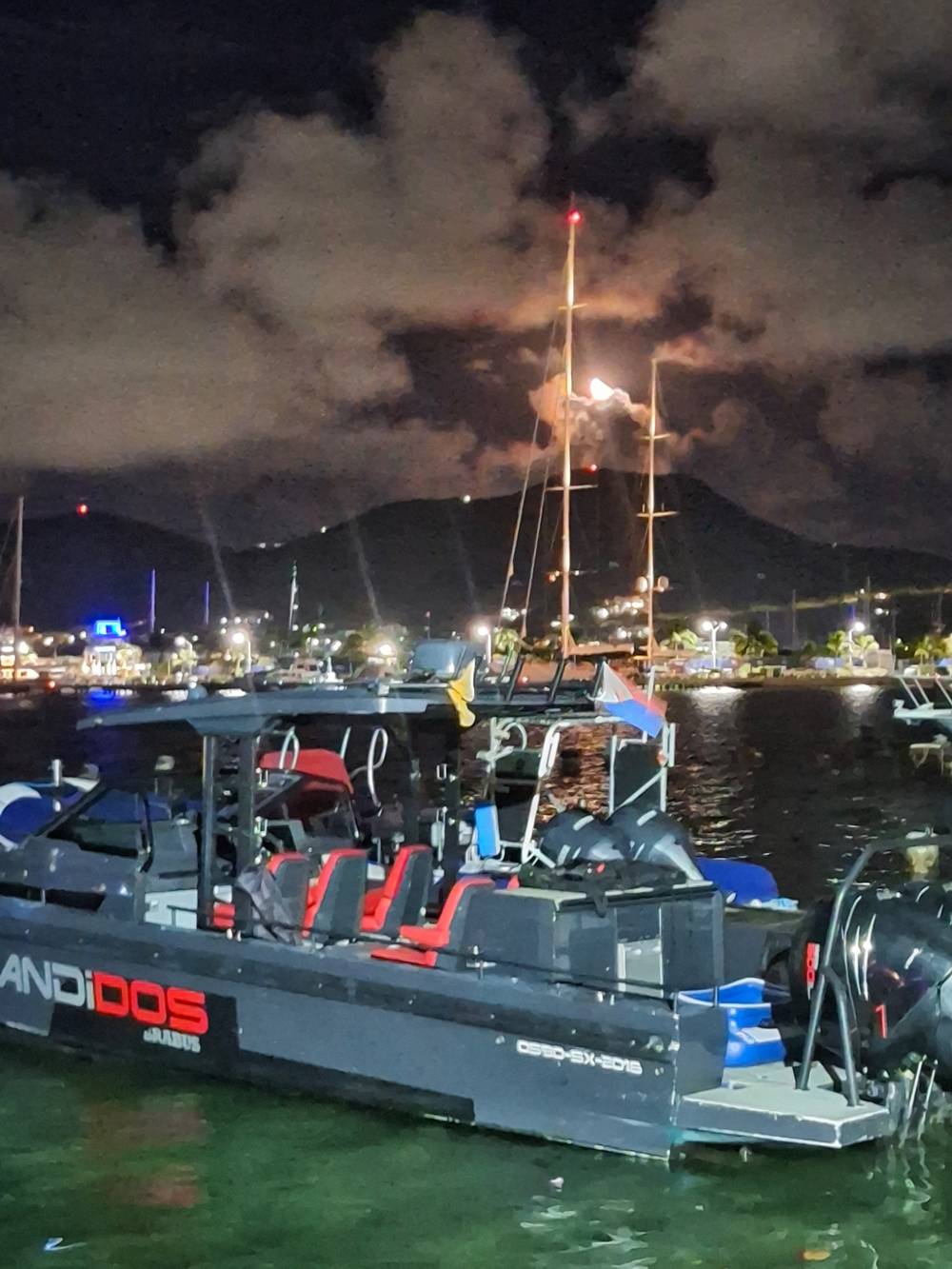 boat on water with night sky above. 