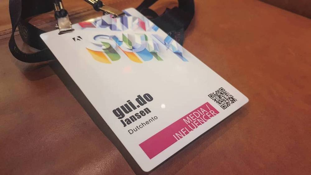 A conference lanyard badge reads "gui.do Jansen, Dutchento, Media Influencer" for Adobe Summit.