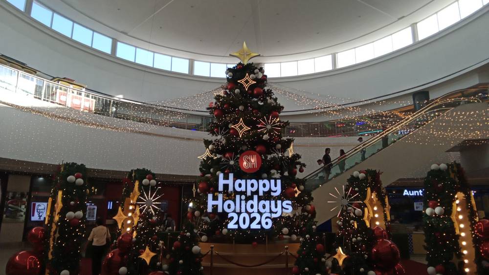 A giant Christmas tree inside SM City Molino with a large message that says, "Happy Holidays 2026".