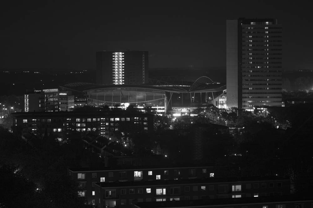 A black-and-white night view of the Utrecht skyline with two illuminated high-rise towers.