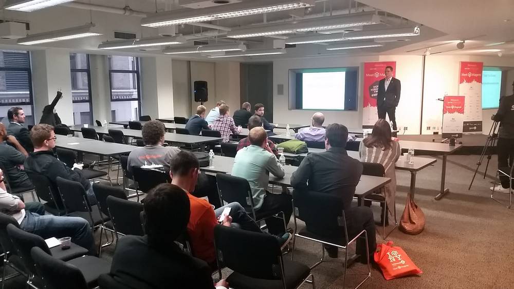A speaker addresses a seated audience at a small meetup event.