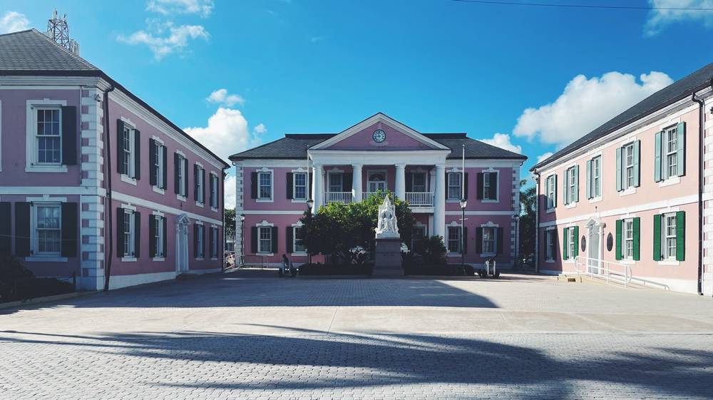 A large, pink house and an empty, central courtyard.