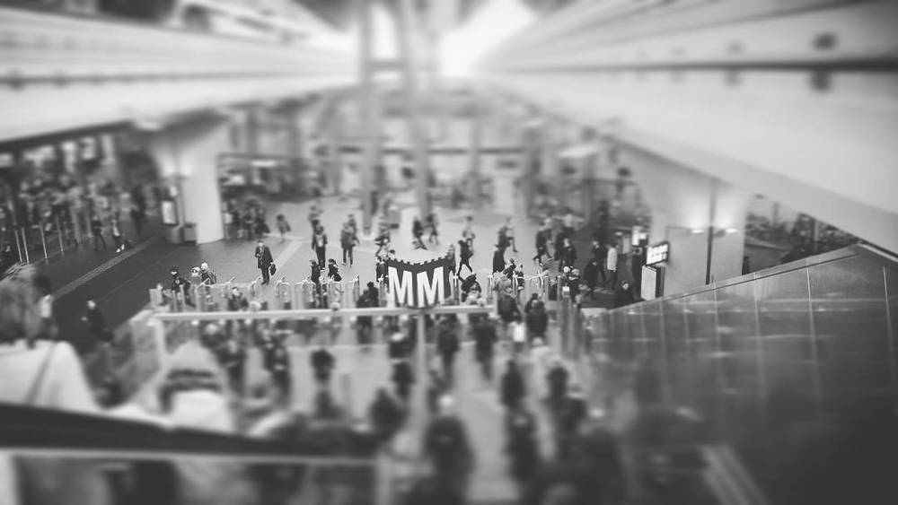 Black and white view of a crowded conference entrance hall from above.
