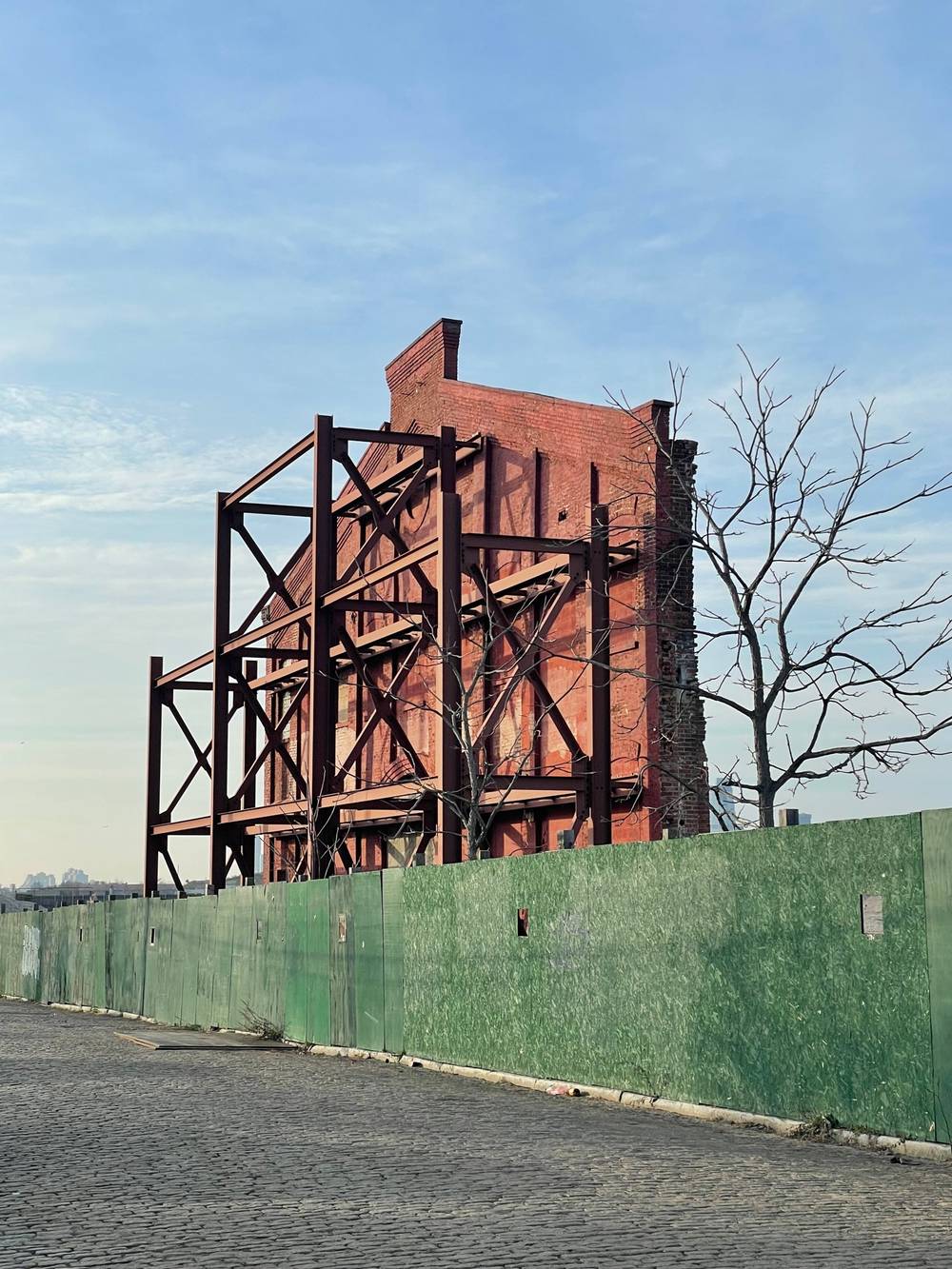 zoom in on brick wall facade held up by a steel brace.