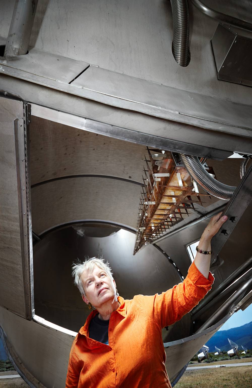 Dr. Jill Tarter at the SETI research facility in the moutnains of California. She is standing beneath a piece of research equipment