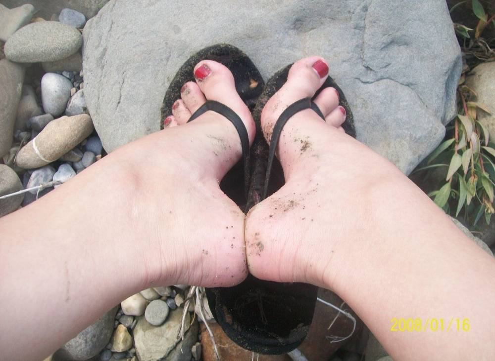 Valerie Rayne shows off her high arches while resting her flip-flopped feet on a rock.
