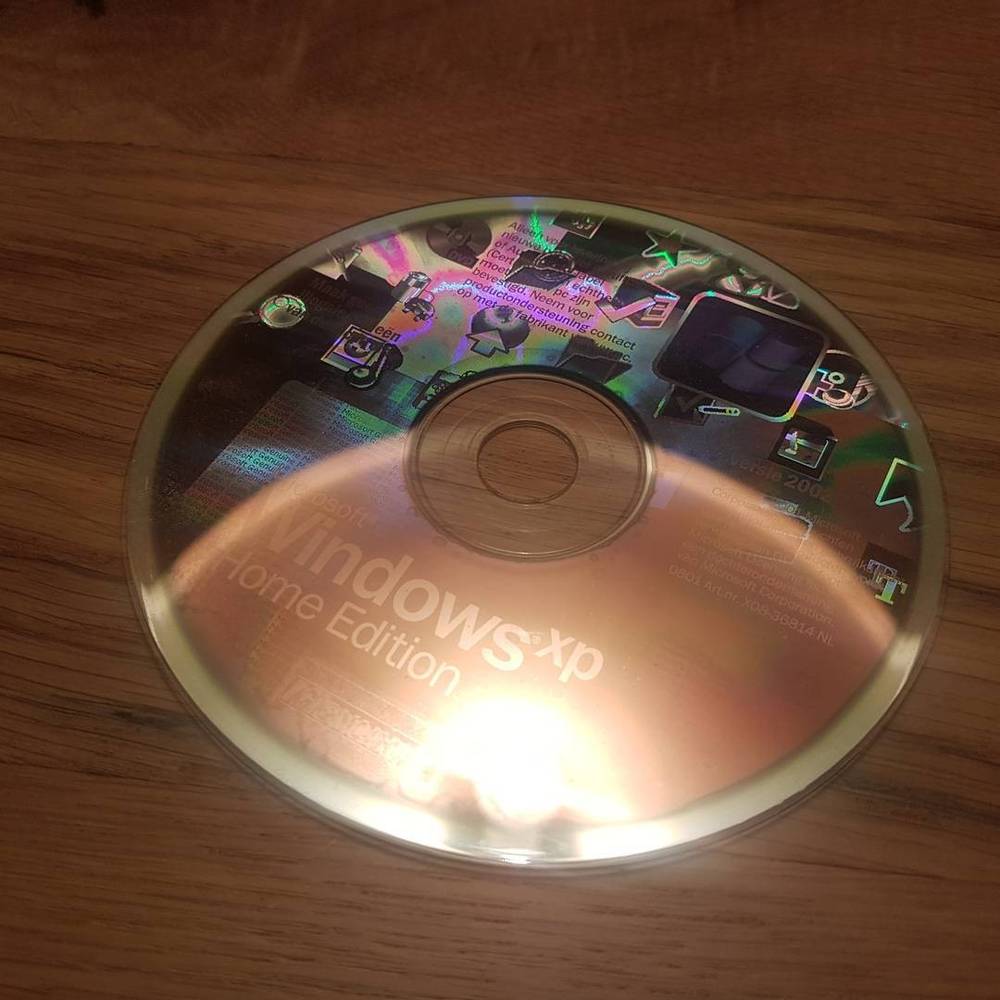 A close-up of a Windows XP Home Edition installation CD.