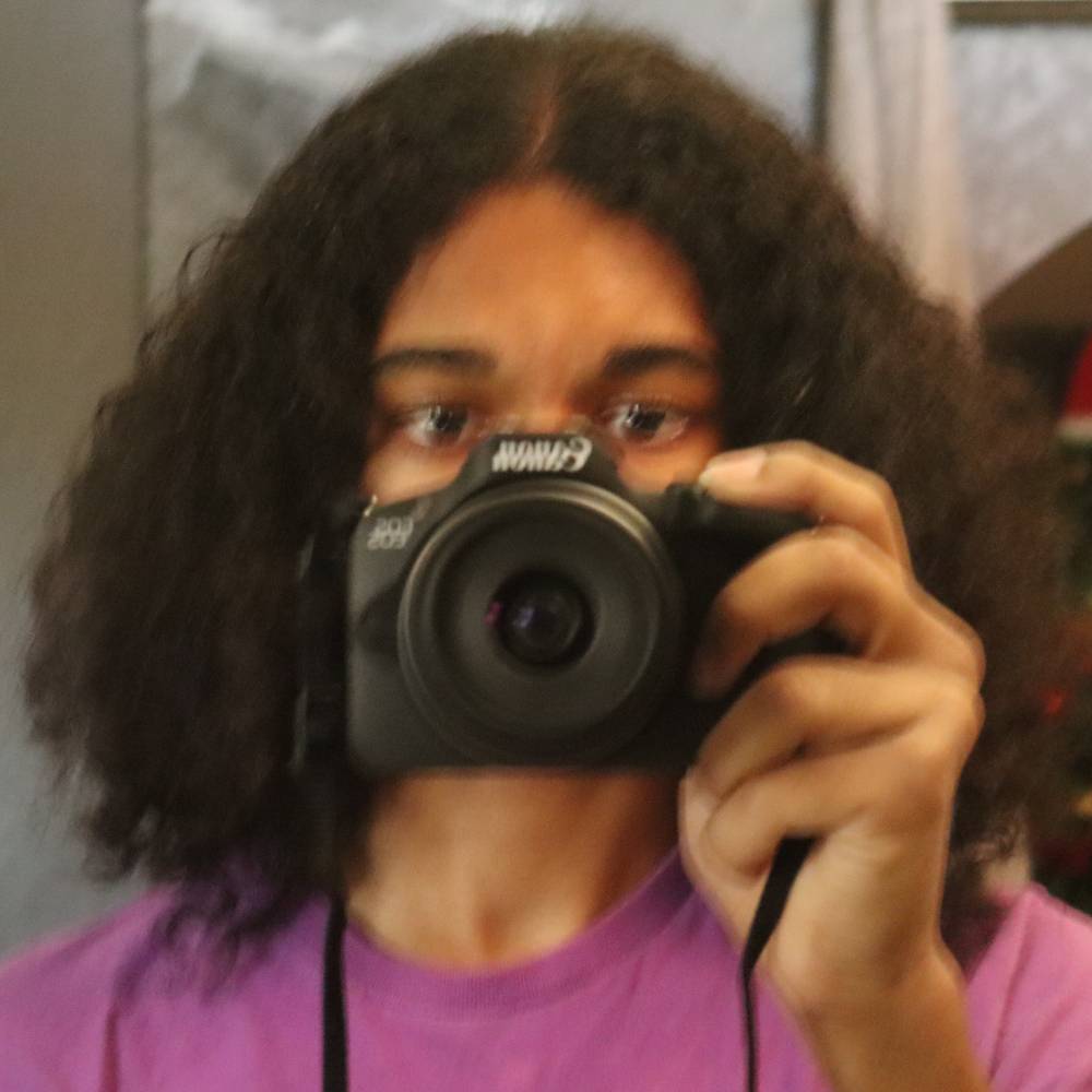 lao holding a camera over her face in front of a mirror in 2026.