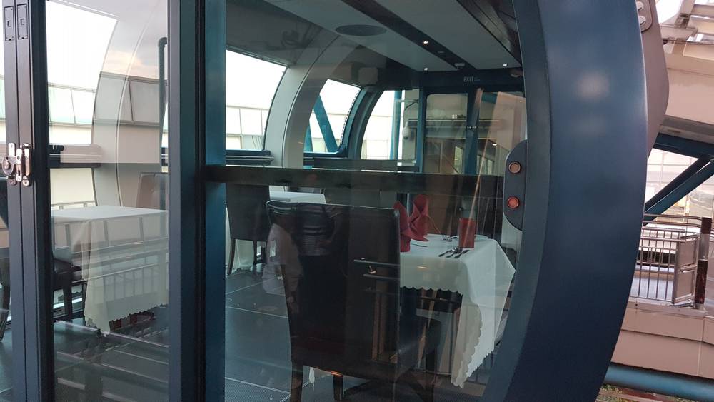 A Singapore Flyer capsule fitted out as a dining pod, with tables set for two.