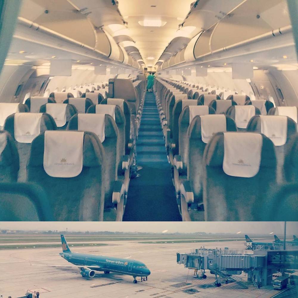 The empty aisle of an airplane cabin with the same jet visible parked on the tarmac below.