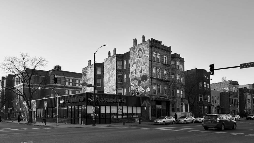 An apartment building over a laundromat has a building-sized portrait that seemed to be shimmering in the sunlight.