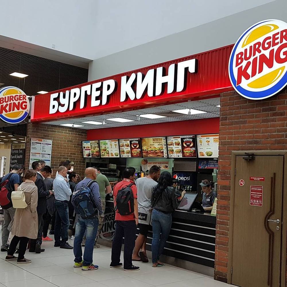 People queuing at a Burger King counter with Russian signage reading "Бургер Кинг".
