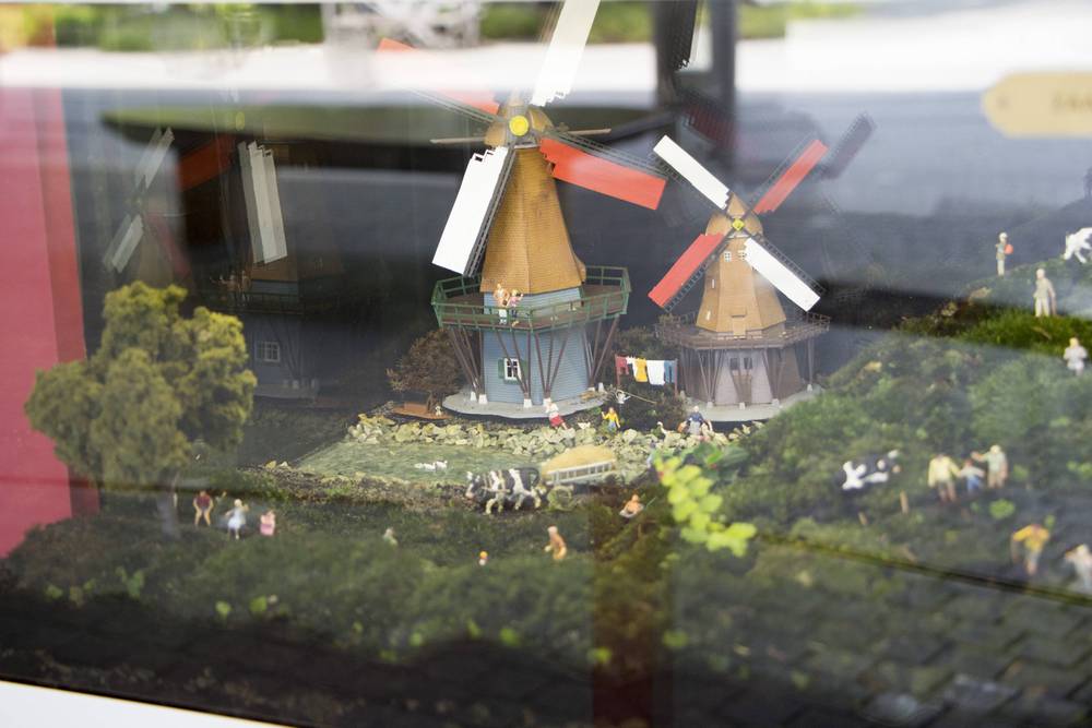 A miniature diorama of Dutch windmills with tiny figures, part of a display inside the Cloud Forest dome.