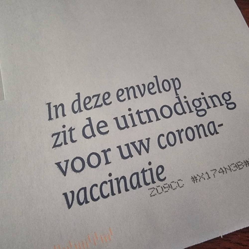 A printed letter reading in Dutch that the envelope contains the invitation for a COVID vaccination.
