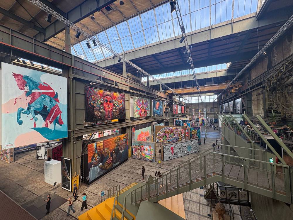 Photo inside the STRAAT Museum in Amsterdam. There are several big canvases with street art on them.