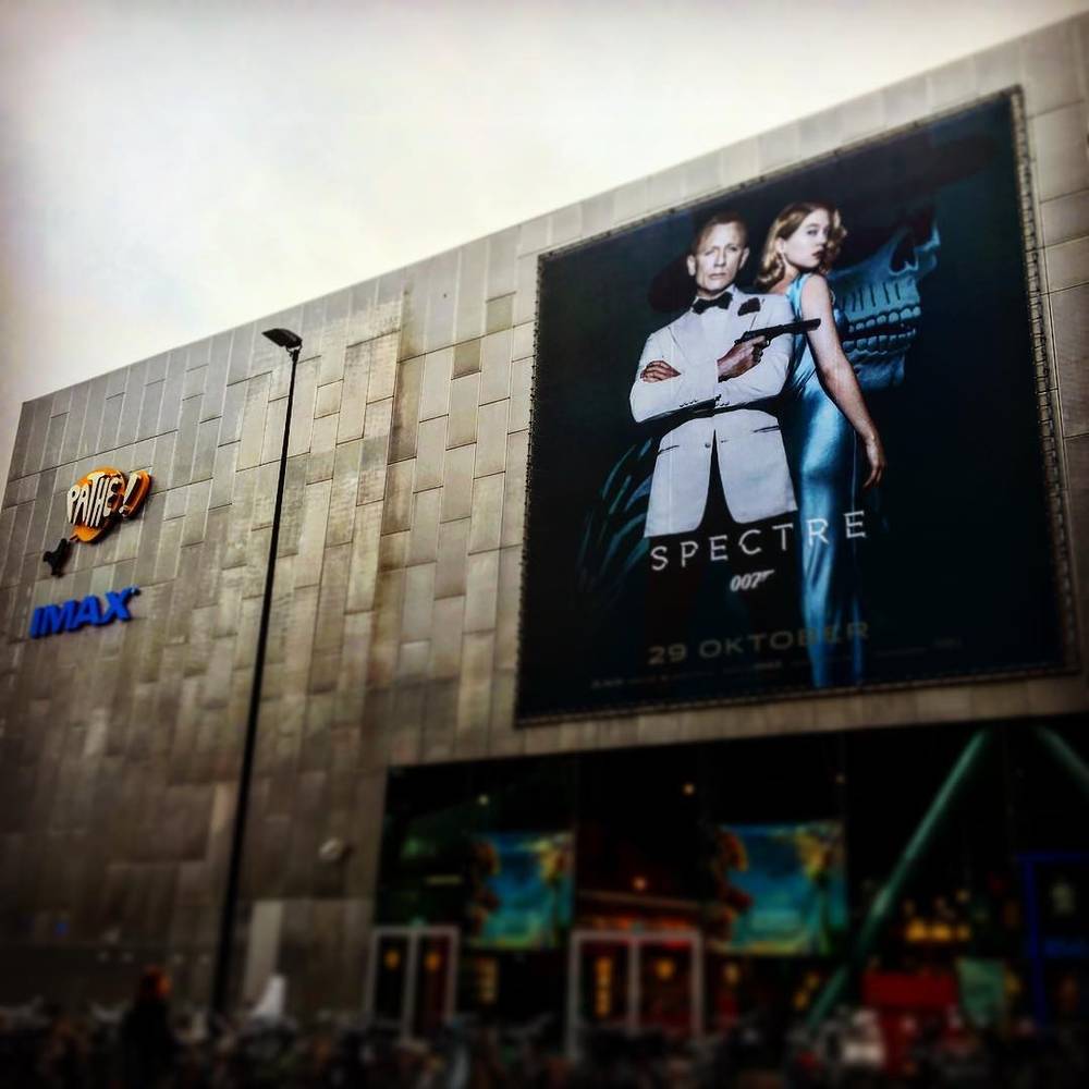 A large outdoor advertisement for the James Bond film Spectre on the side of a cinema building.
